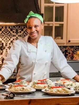 Chef Delsia in the kitchen with plated food